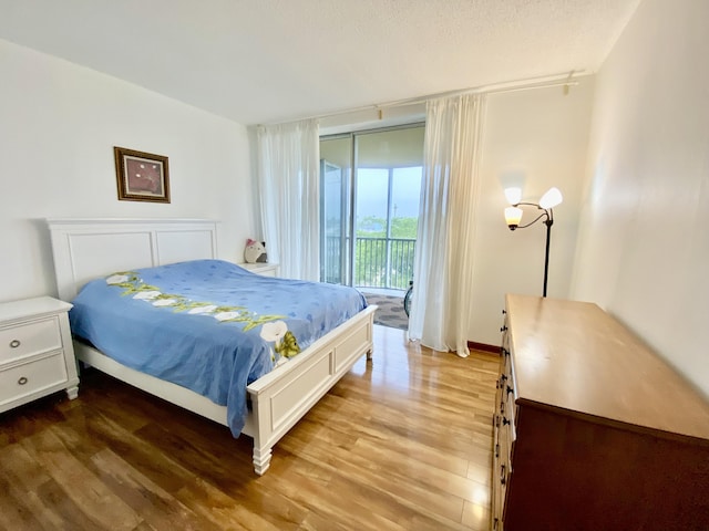 bedroom featuring wood-type flooring and access to exterior