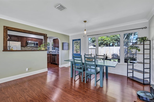 dining area featuring crown molding and dark hardwood / wood-style flooring