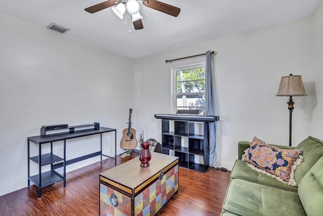 living room featuring ceiling fan and dark hardwood / wood-style flooring