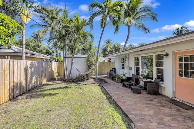 view of yard with central AC, a storage shed, an outdoor living space, and a patio