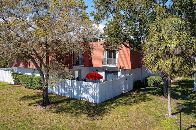 exterior space featuring a yard and a balcony