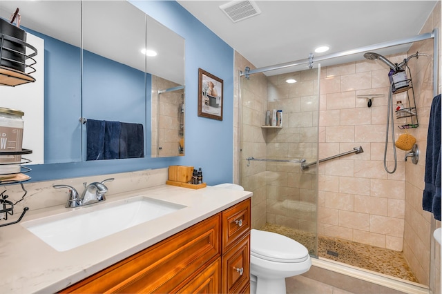 bathroom with vanity, toilet, and a shower with shower door