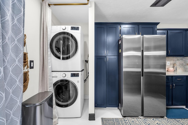 laundry area featuring stacked washer / drying machine