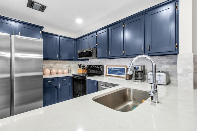 kitchen featuring sink, decorative backsplash, stainless steel appliances, and blue cabinetry