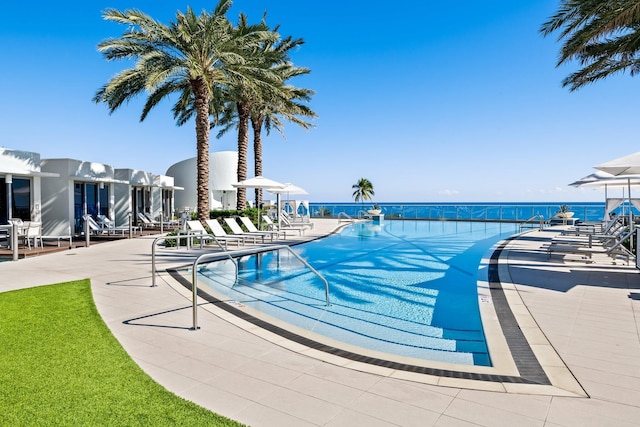 view of pool with a patio area and a water view