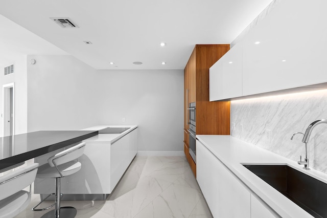 701 N Fort Lauderdale Beach Blvd Unit 504, Fort Lauderdale, FL 33304 - kitchen with modern cabinets, light marble finish floors, white cabinets, and recessed lighting