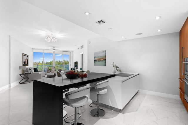 701 N Fort Lauderdale Beach Blvd Unit 504, Fort Lauderdale, FL 33304 - kitchen featuring floor to ceiling windows, light marble finish flooring, a peninsula, brown cabinets, and recessed lighting
