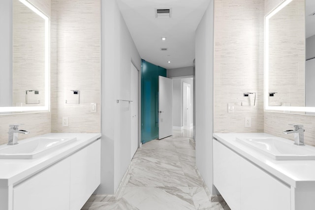 bathroom featuring visible vents, marble finish floor, two vanities, and a sink