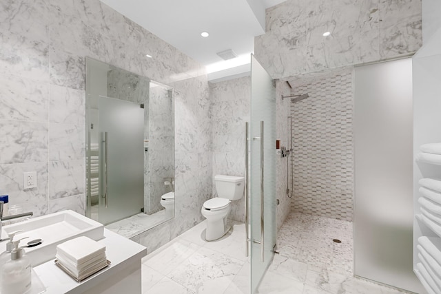 bathroom featuring marble finish floor, a walk in shower, toilet, and tile walls