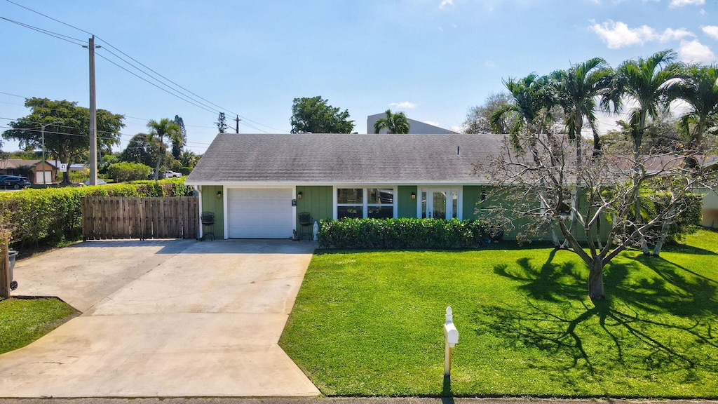 ranch-style house featuring a garage and a front yard