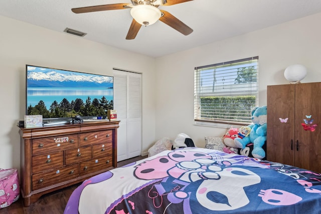 bedroom with a closet, dark hardwood / wood-style floors, and ceiling fan