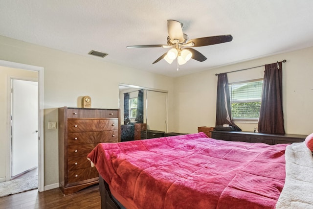 bedroom featuring dark wood-type flooring, ceiling fan, and a closet