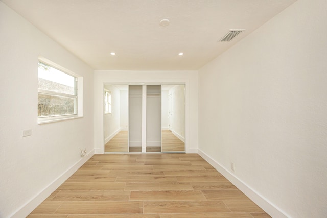 unfurnished bedroom with light hardwood / wood-style floors and a closet