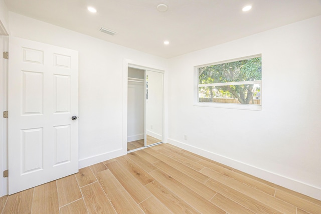 unfurnished bedroom with hardwood / wood-style flooring and a closet