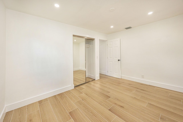 unfurnished bedroom featuring wood-type flooring and a closet