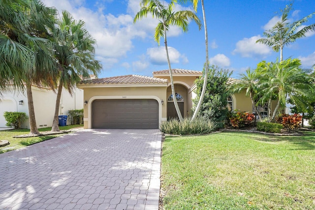 mediterranean / spanish home featuring a garage and a front lawn