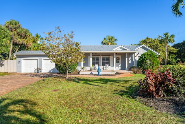 ranch-style home with a garage, covered porch, and a front lawn