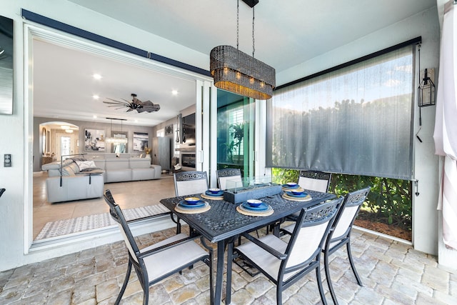 dining space featuring stone tile floors, recessed lighting, arched walkways, and ceiling fan