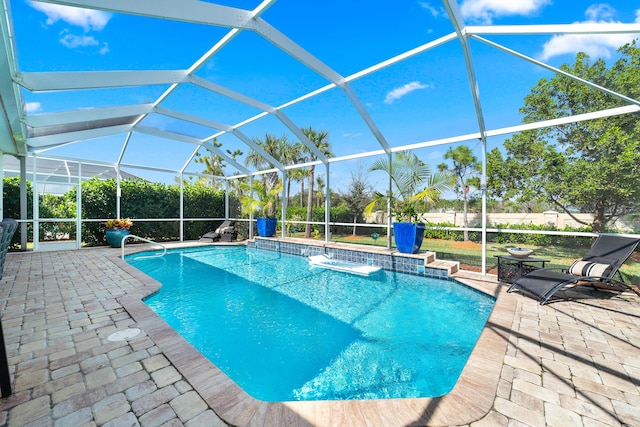 view of pool with glass enclosure, a fenced in pool, and a patio area