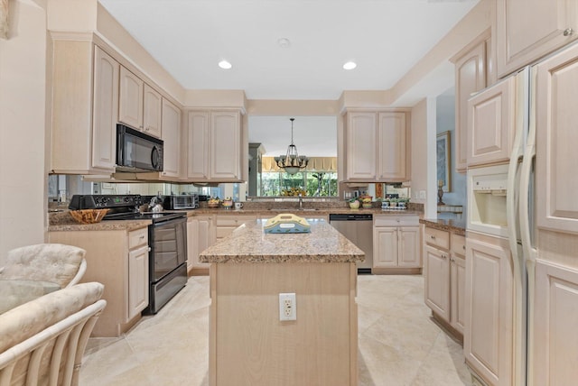 kitchen featuring decorative light fixtures, sink, a center island, black appliances, and light stone countertops