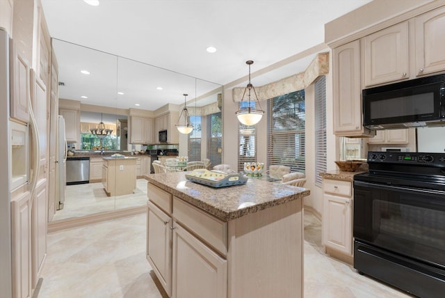 kitchen featuring hanging light fixtures, light stone countertops, a center island, and black appliances