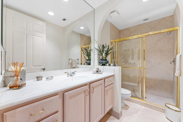 bathroom featuring vanity, a shower with door, and toilet