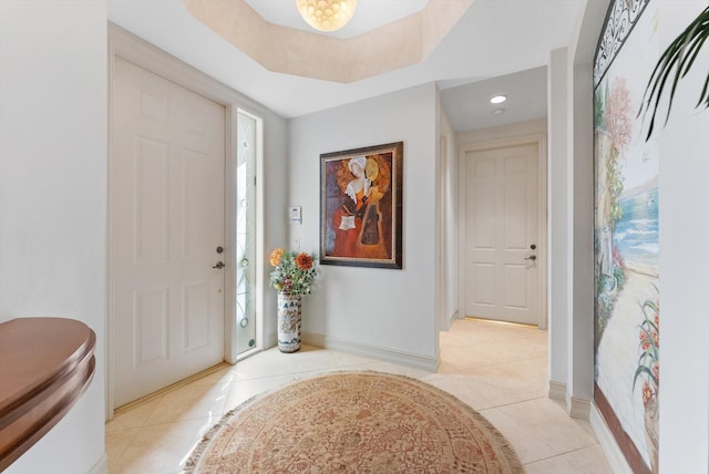 tiled entrance foyer with a raised ceiling