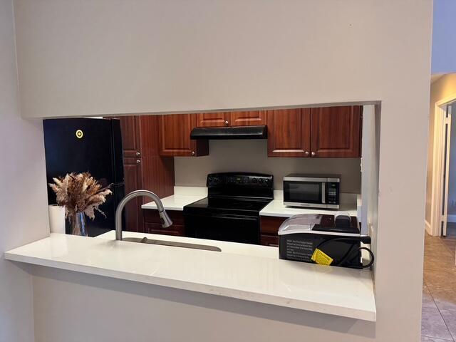 kitchen featuring kitchen peninsula, sink, and black appliances