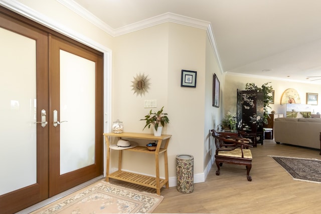 entrance foyer with french doors, baseboards, crown molding, and light wood finished floors