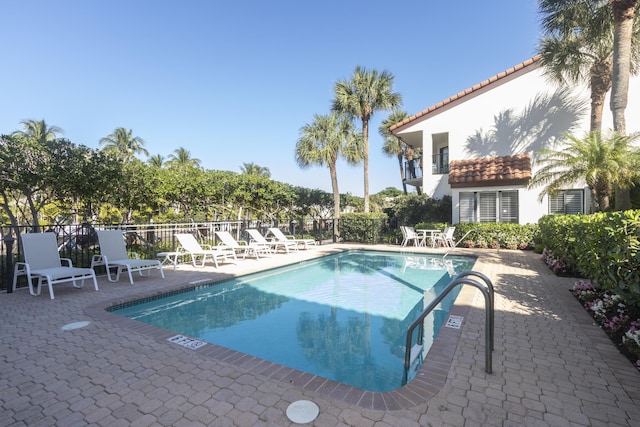 community pool featuring a patio and fence