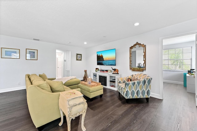 living area featuring recessed lighting, dark wood-style flooring, visible vents, and baseboards