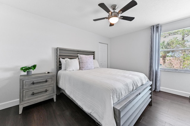 bedroom with dark wood-type flooring, ceiling fan, and baseboards