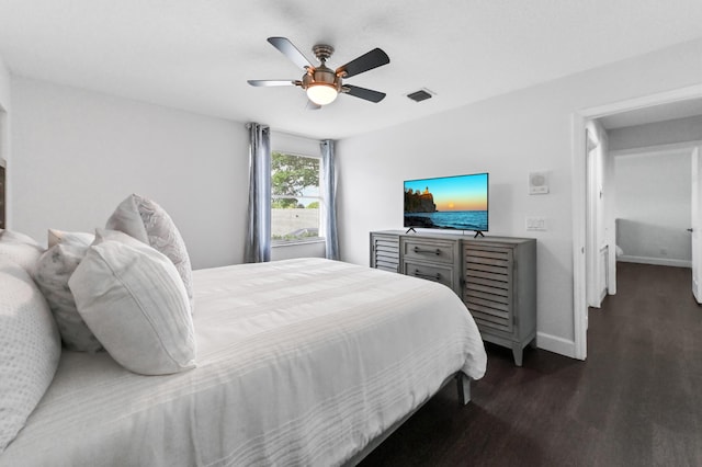 bedroom with dark wood-style floors, a ceiling fan, visible vents, and baseboards