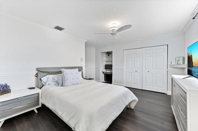 bedroom featuring a closet, visible vents, dark wood-style flooring, and ornamental molding