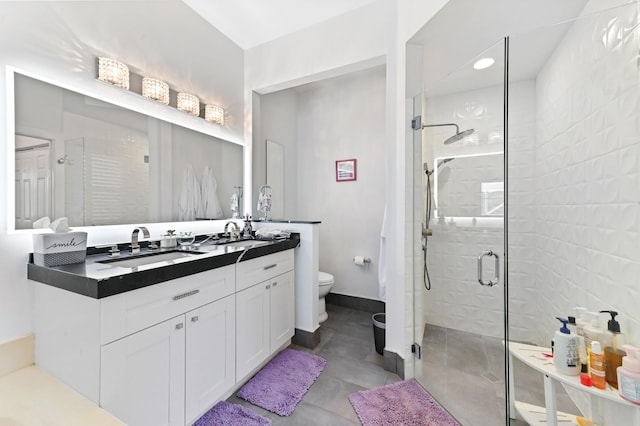 bathroom with toilet, a stall shower, vanity, tile patterned flooring, and baseboards