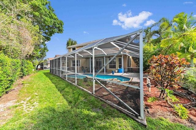 back of house featuring a lawn, a patio area, a lanai, and an outdoor pool