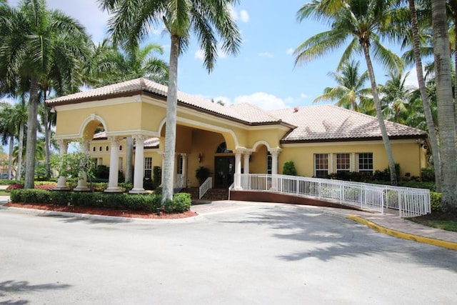 view of front of home featuring a fenced front yard, a tile roof, and stucco siding