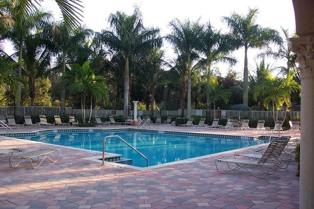 pool with a patio and fence