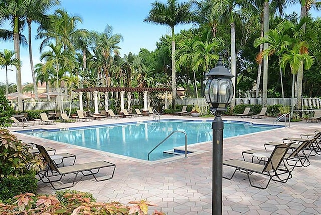 community pool with a patio, fence, and a pergola