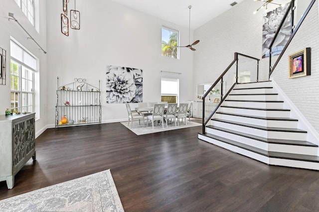 foyer entrance featuring dark wood-style floors, a high ceiling, stairway, and plenty of natural light