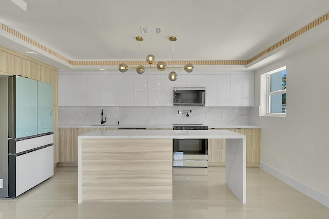 kitchen featuring white cabinetry, refrigerator, range, and decorative light fixtures