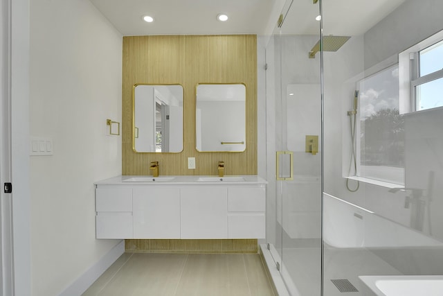 bathroom with a shower with door, vanity, and tile patterned floors