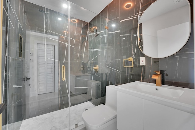 bathroom featuring tile walls, vanity, toilet, and an enclosed shower