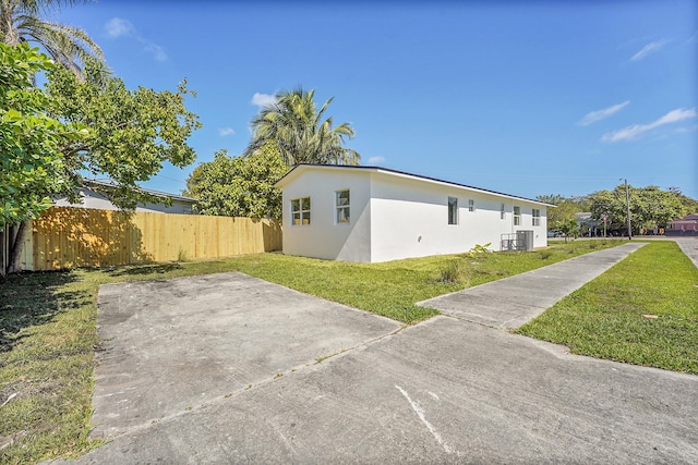 view of side of home featuring a yard and cooling unit