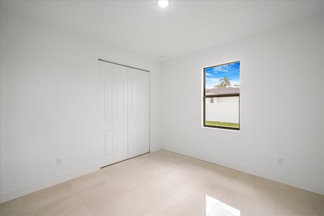 unfurnished bedroom featuring baseboards, a closet, and recessed lighting