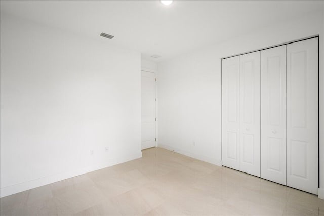 unfurnished bedroom featuring a closet, visible vents, and baseboards