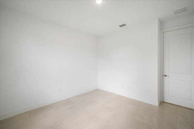 unfurnished room with baseboards, visible vents, and light floors