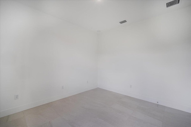 unfurnished room featuring baseboards and visible vents