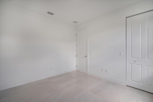 interior space with a closet, visible vents, and baseboards