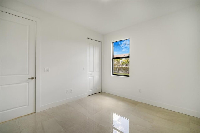 unfurnished bedroom with a closet and baseboards